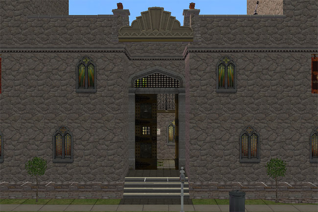 A closer view of the castle entrance shows stone walls, narrow arched windows, front stairs, and a dark doorway between the towers.