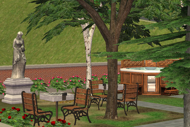 A landscaped back garden includes benches, trees, a statue, flowers, outdoor seating, and a hot tub area tucked near the rear of the hotel.