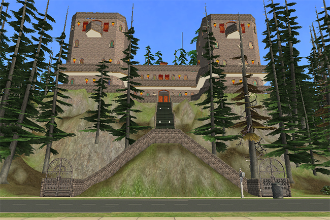 Front exterior view of Greystoke showing the massive cliffside gothic estate with towering stone wings, elevated staircase entrance, forest surroundings, and fortress-like castle architecture overlooking the road below.