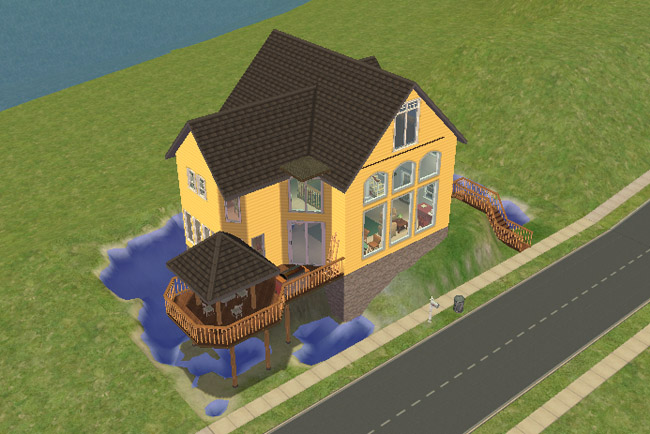 A side view shows the house with tall windows, a covered deck area, railings, stairs, and water tucked around the lot.