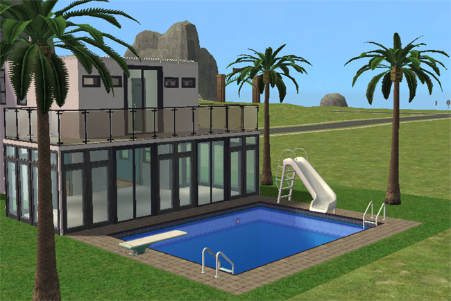 Poolside view featuring the backyard swimming pool with diving board, ladder, slide, glass-walled sunroom, upper balcony, and palm landscaping.