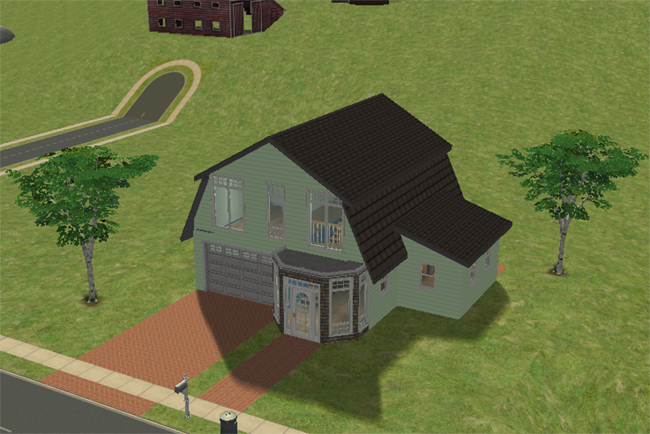 Front exterior view of Barn Conversion 2, a converted barn-style home with pale green siding, dark roofing, attached garage, glass entry porch, brick driveway, and open grassy yard.