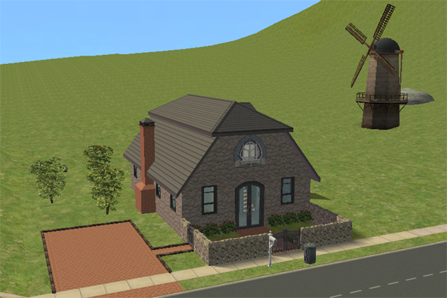A stone barn conversion home with a brick driveway, chimney, arched front window, double front doors, and a low walled garden.