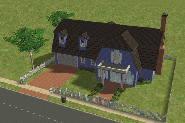 A blue barn conversion with a dark roof, covered front porch, white fencing, red-trimmed windows, garage, flower beds, and open lawn.
