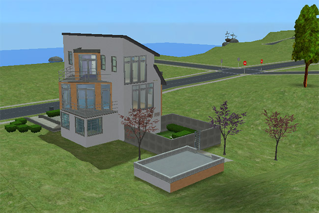 Rear angled view of the house showing the sloped roofline, fenced side courtyard, upper balcony, and a raised outdoor patio area.